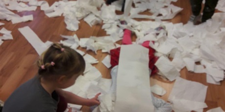 Powiększ grafikę: Dzieewczynka przykrywająca koleżankę papierem